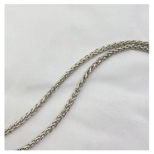 Close-up of a high-polish silver wheat chain with elegant woven texture for small square bags