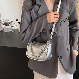 Sac bandoulière argenté métallisé avec texture crocodile et chaîne sur un modèle