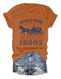 Détail d'un t-shirt orange avec motif vintage et d'un short en jean effet vieilli