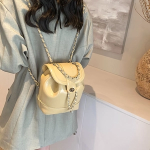 Sac à dos chic en cuir verni beige avec chaînes dorées et fermeture tournante