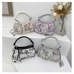 Detail of embroidered floral jacquard handbags with metallic chain straps and drawstrings
