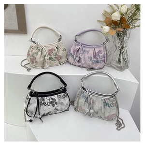 Detail view of four Chinese style embroidered handbags with pearl drawstring and chains