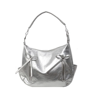 Silver metallic hobo bucket bag with lychee texture and rivet bow details on white background