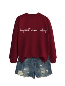 Dettaglio felpa bordeaux con scritta Happiest When Reading e pantaloncini di jeans strappati