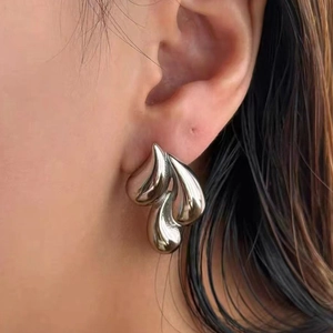 Minimalist stainless steel teardrop earrings with fluid aesthetic on a female model