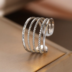 Silver geometric hollow layered open ring with hammered and beaded texture on gold box