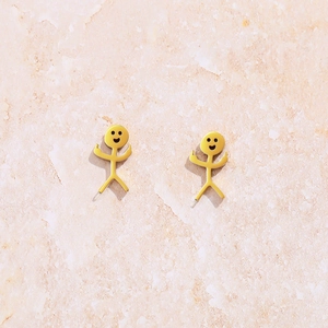 Boucles d'oreilles bonhomme allumette doré avec visage souriant et geste du majeur rebelle