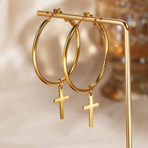 Gothic 18k gold plated stainless steel hoop earrings with cross pendants on a display