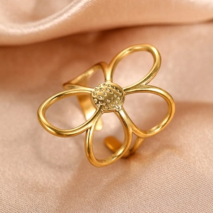 Bague fleur évidée dorée minimaliste avec texture sur fond de soie de couleur champagne