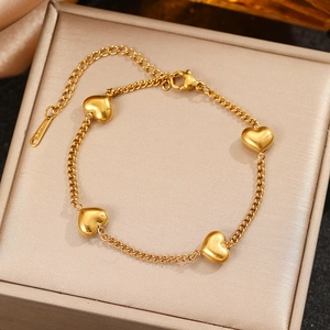 Polished 18K gold-plated stainless steel bracelet with 3D heart charms on a satin box