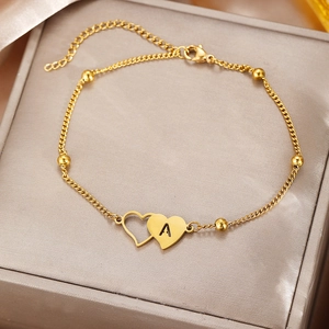 Detail of gold-plated stainless steel anklet with double heart charms and letter A engraving