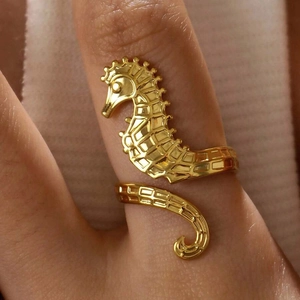 Golden seahorse open ring in stainless steel with detailed scales worn on a finger