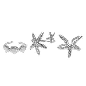 Macro view of textured starfish and scallop shell rings set in matte silver finish