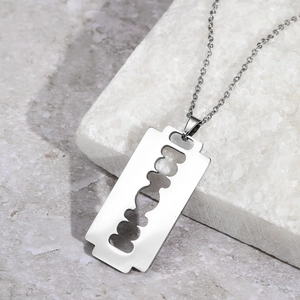 Unisex stainless steel razor blade pendant necklace with a polished silver punk style finish