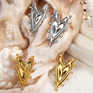 French style 18K gold and silver heart stud earrings with beaded edges on velvet background