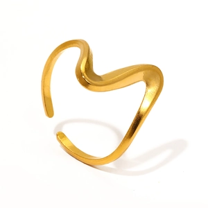 Détail d'une bague ouverte dorée ondulée avec finition polie et design artistique moderne