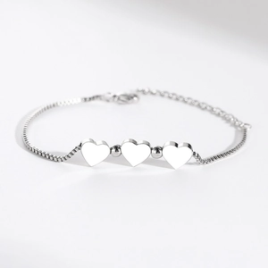 Polished stainless steel box chain bracelet featuring triple heart charms and lobster clasp