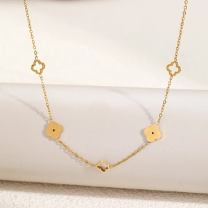 Macro shot of gold hollow-out four-leaf clover pendant on stainless steel chain