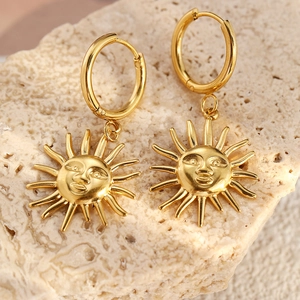 Detailed macro view of 18K gold sun flower earrings on natural stone background