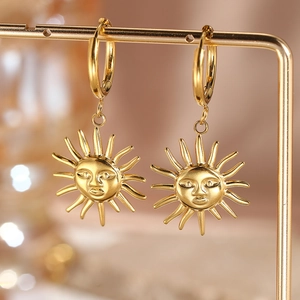 Macro shot of 18K gold plated sunflower face earrings on a metal jewelry display