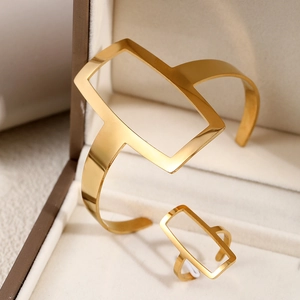 Detail of minimalist gold hollow geometric bracelet and matching ring set in jewelry box