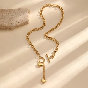 Détail d'un collier pendentif coeur doré avec fermoir à bascule sur surface