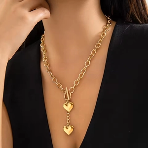 Détail du collier à pendentif cœur doré avec fermoir à bascule sur chaîne en acier