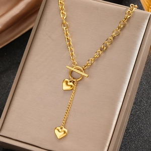 Collier chic avec pendentif cœur doré et fermoir à bascule sur présentoir à bijoux