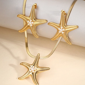 Detail of gold starfish jewelry set with white pearls and textured metallic finish