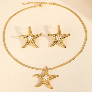 Detailed view of starfish jewelry set with pearl centers and gold snake chain necklace