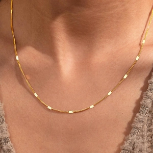 Close-up of a delicate 18K gold-plated O-chain necklace with polished rectangular bar accents