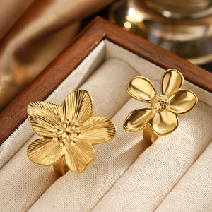 Exquisite gold stainless steel floral rings set with detailed petal textures on silk