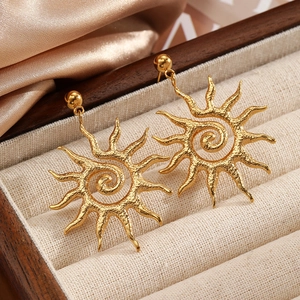 Vintage golden sun drop earrings with hammered texture and spiral pattern on velvet liner