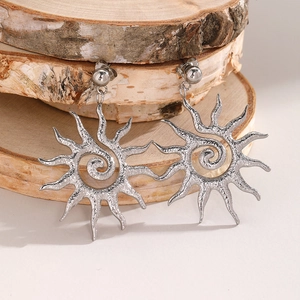 Silver vintage sun drop earrings with hammered spiral texture on natural birch wood background
