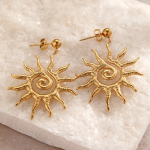 Detail of gold sun drop earrings featuring hammered texture and spiral core on stone