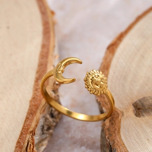 Macro detail of sun and moon adjustable ring on natural wood with a gold finish