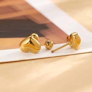 Détail des boucles d'oreilles cœur doré avec fermoir à vis et finition polie brillante