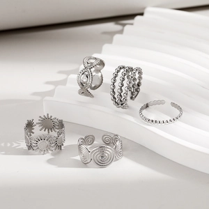 Close-up of adjustable stainless steel rings set featuring geometric and sun patterns