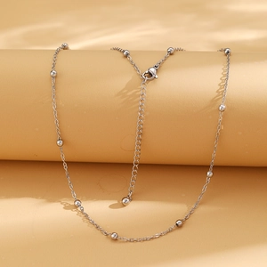 Détail du collier à billes argenté avec fermoir mousqueton et chaîne d'extension ajustable