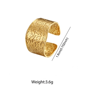 Detail of wide C-shaped gold ring featuring hammered texture and 1.8cm width