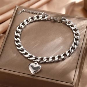 Polished stainless steel Cuban link anklet featuring a solid heart charm on silk fabric