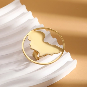 Detailed close-up of gold stainless steel ring with Africa map cutout on a white stone base