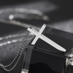 Polished stainless steel cross pendant necklace for men and women on a dark background