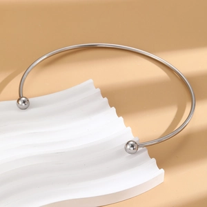 Minimalist silver stainless steel C-shape collar necklace with round beads on white stand
