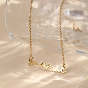 Close-up of golden mama cursive pendant necklace with rippled water shadow background