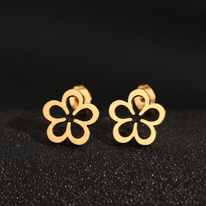 Detailed macro shot of hollow gold flower earrings with polished metal petals