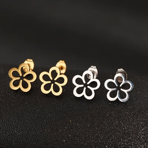 Detailed view of hollow flower stud earrings in polished gold and silver finishes