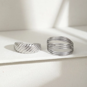 Minimalistisches Set aus silbernen Edelstahlringen mit Spiral- und Liniendesign auf Weiß
