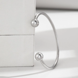 Detail of silver adjustable cuff bracelet featuring polished sphere ends on a jewelry box