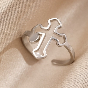 Close-up of adjustable silver cross ring with hollow design on champagne silk fabric